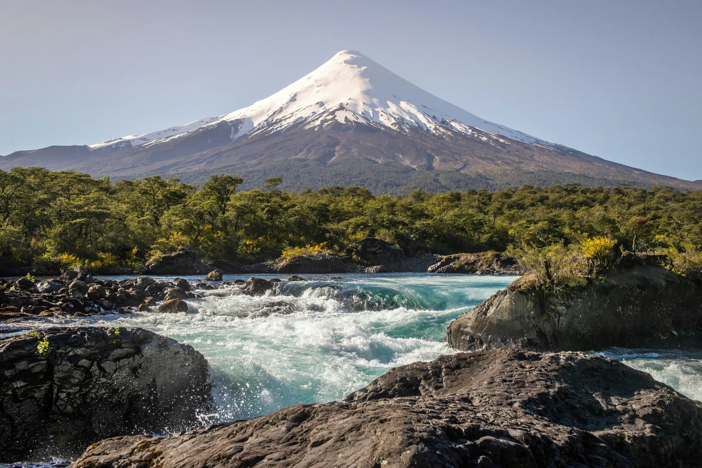 Snow-capped Volcán Osorno above a rushing river and native forest, Los Lagos