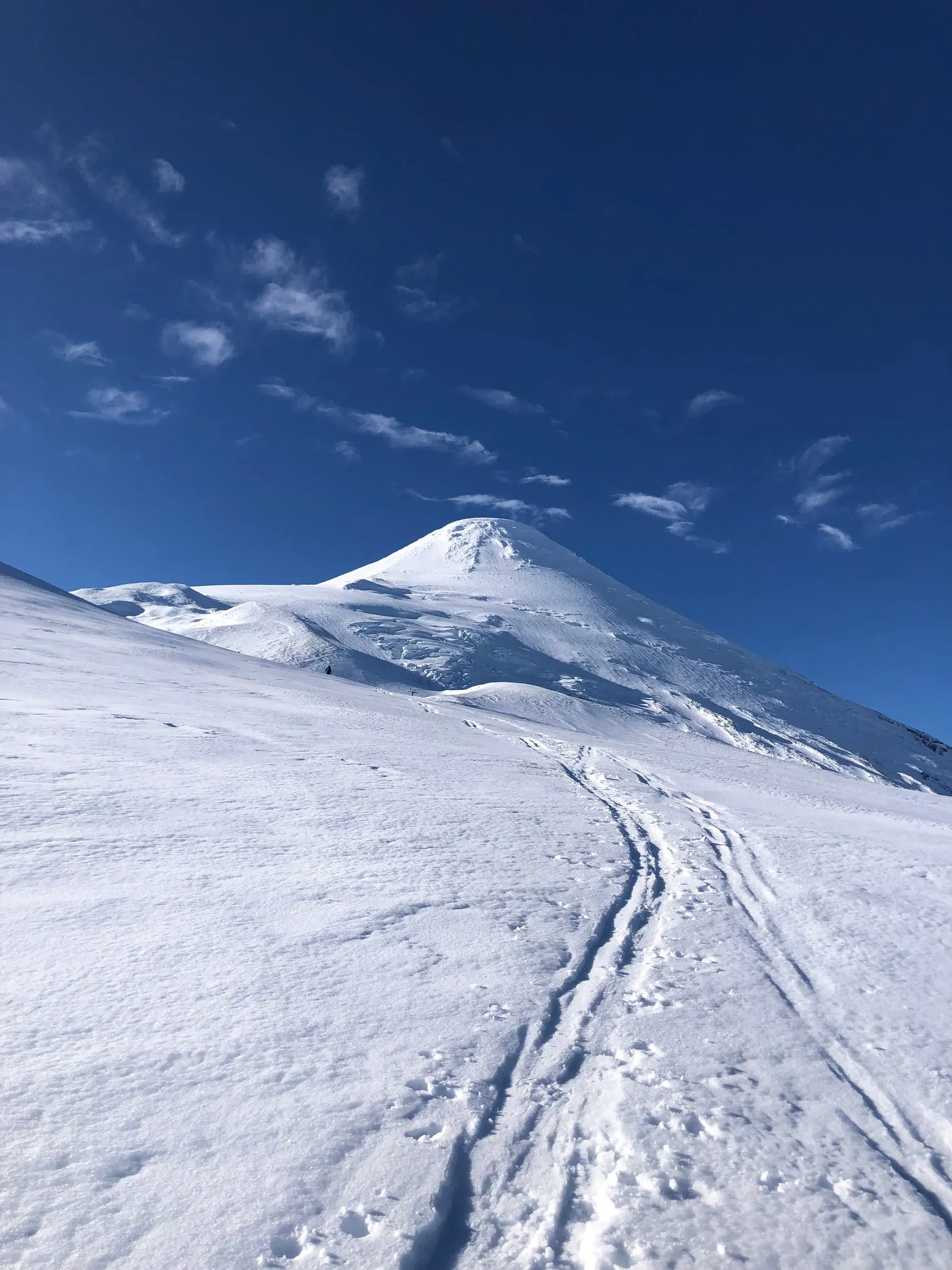 Ski tracks leading up to a snow-covered volcano summit in southern Chile