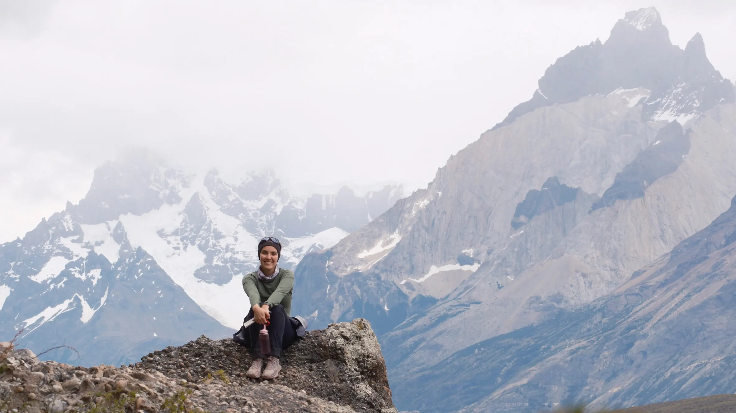 Hiker resting at a viewpoint facing the Paine massif, Torres del Paine